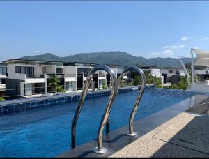 ein Pool mit zwei Metallschienen neben einem Gebäude in der Unterkunft Laguna Parkside 5 bedroom villa with pool near the beach in Laguna Phuket