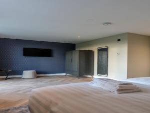 a bedroom with a large bed and a flat screen tv at Modern villa in De Cocksdorp near the beach in De Cocksdorp