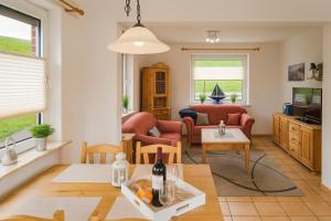 a living room with a couch and a table at Lüttjes Diekhuus in Butjadingen OT Tossens