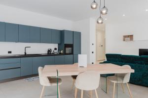 a kitchen and dining room with a wooden table and chairs at Gc Luxury Apartments e Spa in Santa Margherita di Belice