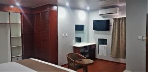 NataにあるPelican Lodge and Campingのベッド、テーブル、デスクが備わる客室です。
