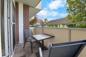 a patio with a table and chairs on a balcony at Ferienwohnung Seehase in Hooksiel