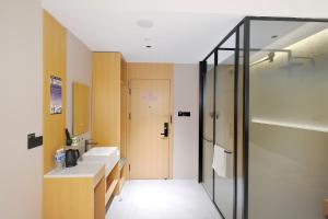 a bathroom with two sinks and a shower at Huayi Select Hotel Liujiayao Subway Station Hengliutiao Branch in Beijing