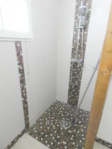 a shower in a bathroom with a tile floor at La caminade in Gourbera +20 photos