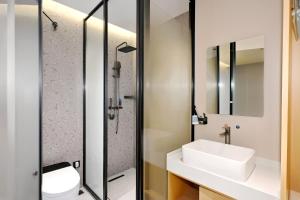 a bathroom with a sink and a shower at Huayi Select Hotel Liujiayao Subway Station Hengliutiao Branch in Beijing
