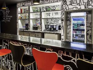 a restaurant with a bar with chairs and a refrigerator at ibis Juiz de Fora in Juiz de Fora +25 photos