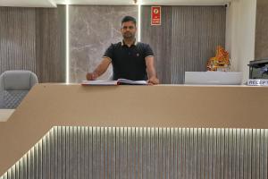 a man standing behind a table with a book at Hotel Bliss express' New delhi city center in New Delhi