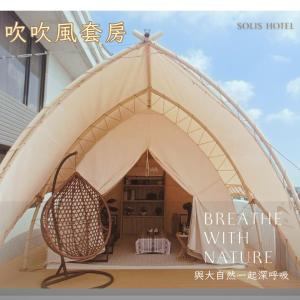una tenda con una sedia di vimini all'interno di 金金禮寓Solis hotel a Jinhu