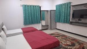 a bedroom with a bed and a flat screen tv at Virasat Villa in Mount Ābu