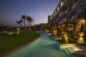 un edificio con una passerella accanto a un prato con palme di Movenpick Waterpark Resort & Spa Soma Bay a Hurghada