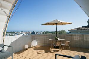 a patio with a table and an umbrella on a roof at 金金禮寓Solis hotel in Jinhu