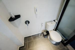 een kleine badkamer met toilet en douche bij Escotel Vanili Guest House in Canggu +24 foto's