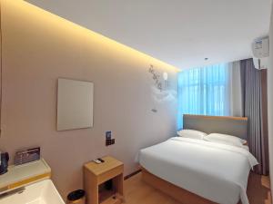 a hotel room with a bed and a sink at Huayi Select Hotel Liujiayao Subway Station Hengliutiao Branch in Beijing