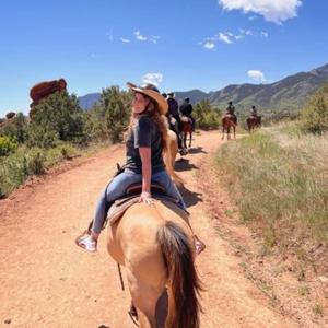 a woman riding a horse on a dirt road at Villa Daniela Restrepo in Restrepo