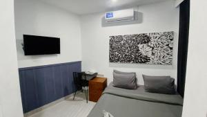 een kamer met een bed en een flatscreen-tv bij Escotel Vanili Guest House in Canggu
