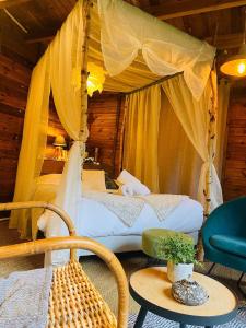 a bedroom with two beds with a canopy at Refuge de Campagne Le Chalet in Chaix +9 photos