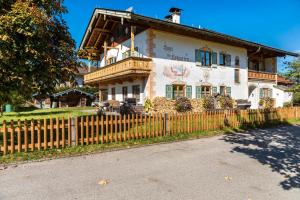 a house with a wooden fence in front of it at Ferienwohnungen am Hofgarten in Krün