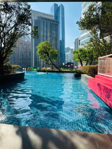 a pool in the middle of a city with tall buildings at 8 Kia Peng by 8 Suites kL in Kuala Lumpur