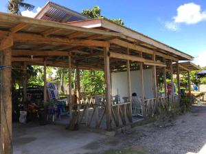 a wooden pavilion with a table and chairs at Eme's Apartelle in General Luna
