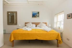 a bedroom with a bed with a yellow blanket at Kemp Town Mews - Parking - by Brighton Holiday Lets in Brighton & Hove