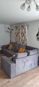 a living room with a gray couch with yellow pillows at Casa Ginguba in Saint-Émilion