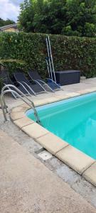 a swimming pool with chairs next to at Casa Ginguba in Saint-Émilion