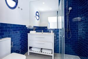 ein blau gefliestes Bad mit einem Waschbecken und einer Dusche in der Unterkunft Playa Jardín Sun & Dreams in Puerto de la Cruz + 35 Fotos