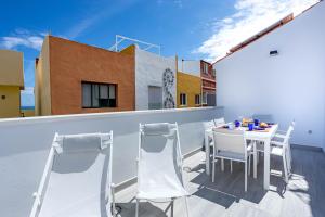 ein Balkon mit Tisch und Stühlen auf einem Gebäude in der Unterkunft Playa Jardín Sun & Dreams in Puerto de la Cruz