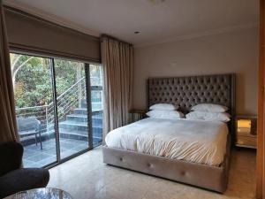 a bedroom with a large bed and a balcony at Silva Villa in Bedfordview +59 photos
