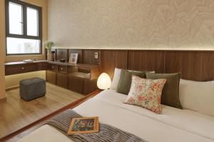 a bedroom with a bed and a table and a window at HongHome Compass One in Ga Phú Văn