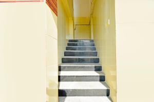 a staircase in a hallway with blue and white tiles at Super Hotel O MAK RESIDENCE in Shamshabad