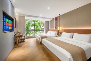 a hotel room with two beds and a flat screen tv at Xi'an Xichen Hotel in Xi'an