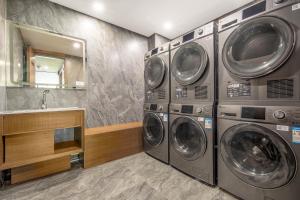 a laundry room with three washing machines and a sink at Xi'an Xichen Hotel in Xi'an +28 photos