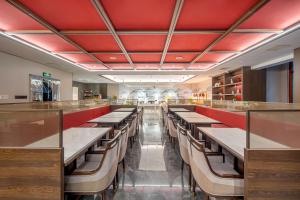 a dining room with long tables and benches at Xi'an Xichen Hotel in Xi'an