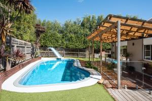 a swimming pool with a slide in a yard at Malibu in Mt Martha with solar heated pool in Mount Martha