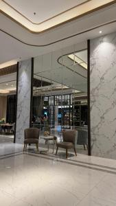 a lobby with chairs and tables in a building at Apartemen Anderson pakuwon mall Luxury Studio Apartment Connecting Mall, Pool & City View 37B in Surabaya