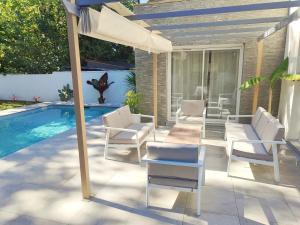 patio con sedie e ombrellone accanto alla piscina di Maison contemporaine a Floirac