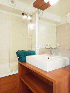 a bathroom with a white sink and a mirror at Appartement entier dans résidence de tourisme in Azille