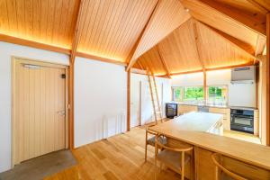 a kitchen with a wooden table and wooden ceilings at The Nest Teshikaga in Teshikaga