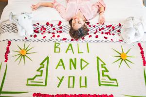 een klein meisje liggend op een bed met een verjaardagstaart bij The Wina Villa Canggu by The Wina Resorts in Canggu +62 foto's