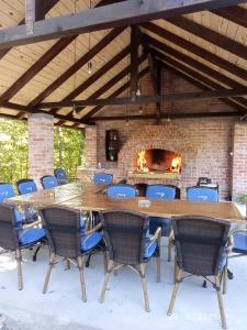 a large wooden table and chairs in front of a brick fireplace at Vikendica Šššuma in Srbac +36 photos
