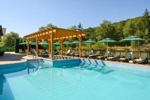 a swimming pool with chairs and umbrellas at Thermal Camping Velingrad in Velingrad