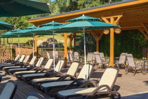 a bunch of chairs and umbrellas on a deck at Thermal Camping Velingrad in Velingrad