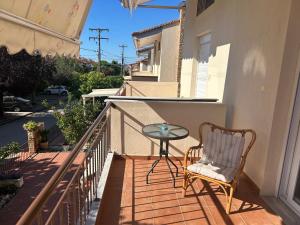 a glass table and a chair on a balcony at Kaly Mare Sithonia in Kalyves Poligirou