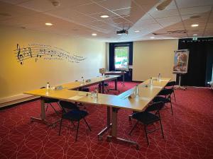 a room with tables and chairs with music on the wall at Ibis Styles Toulouse Blagnac Aéroport in Blagnac