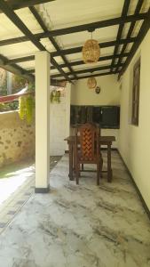 a patio with a table and a bench and a ceiling at Lisky villa Blue Beach Hiriketiy in Dickwella