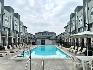 una piscina con sedie, tavoli e edifici di #Marbella Lane-Luxury Designer 3BR Home Disneyland ad Anaheim