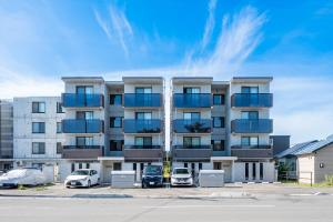 an apartment building with cars parked in a parking lot at SERAPHIC 千歳MS101 in Chitose