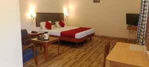 a hotel room with a bed with red pillows at Ksr woodland Residency in Kodaikānāl