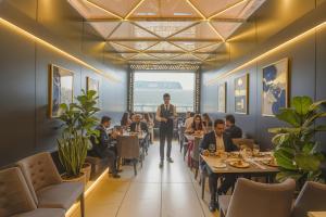 a man walking through a restaurant with people sitting at tables at Fabhotel Nexus Inn near Nesco in Mumbai